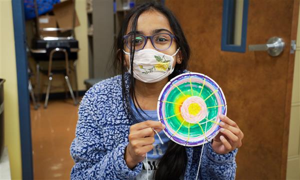 student creates woven craft